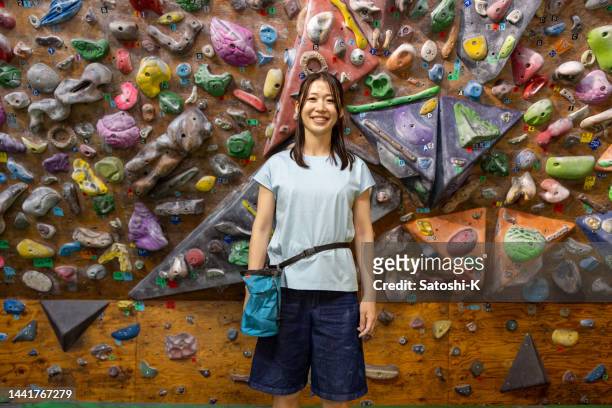 porträt einer bouldersportlerin - dreiviertellänge - kletterwand kletterausrüstung stock-fotos und bilder