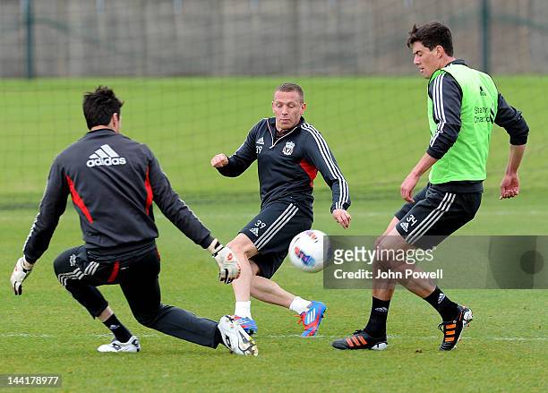 Craig Bellamy competes with Martin Kelly and Alexander Doni of Liverpool in action during a training session at Melwood training Ground on May 11,...