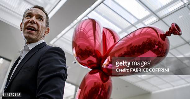 Artist Jeff Koons' poses next to "Balloon Dog " on May 11, 2012 during an exhibition preview at the Fondation Beyeler museum in Basel. The Fondation...