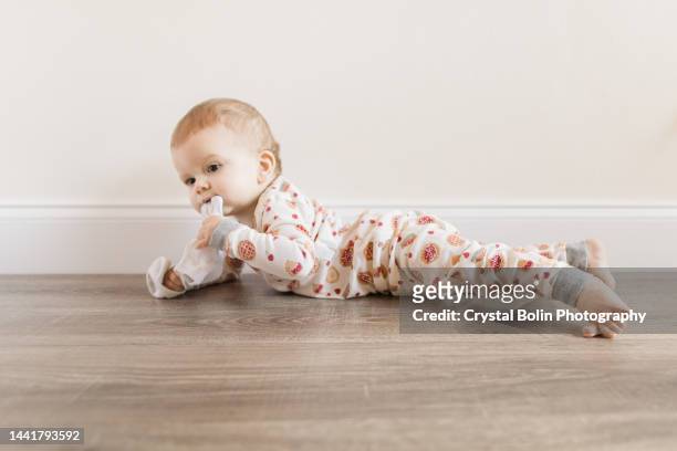 10-month-old baby boy being funny with a sock hanging from his mouth while wearing cozy organic cotton cherry pie pajamas for thanksgiving at home in november 2022 - dog thanksgiving stock pictures, royalty-free photos & images