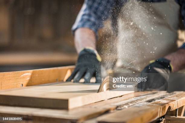 saw blade of electric circular saw cutting off stripe of material - arbetshandske bildbanksfoton och bilder