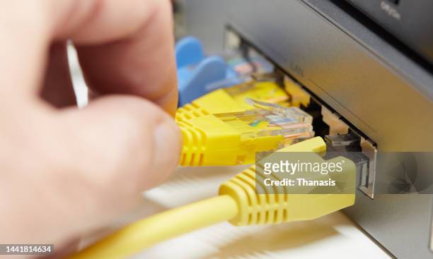 ethernet cables connected to a computer network - largura de banda - fotografias e filmes do acervo