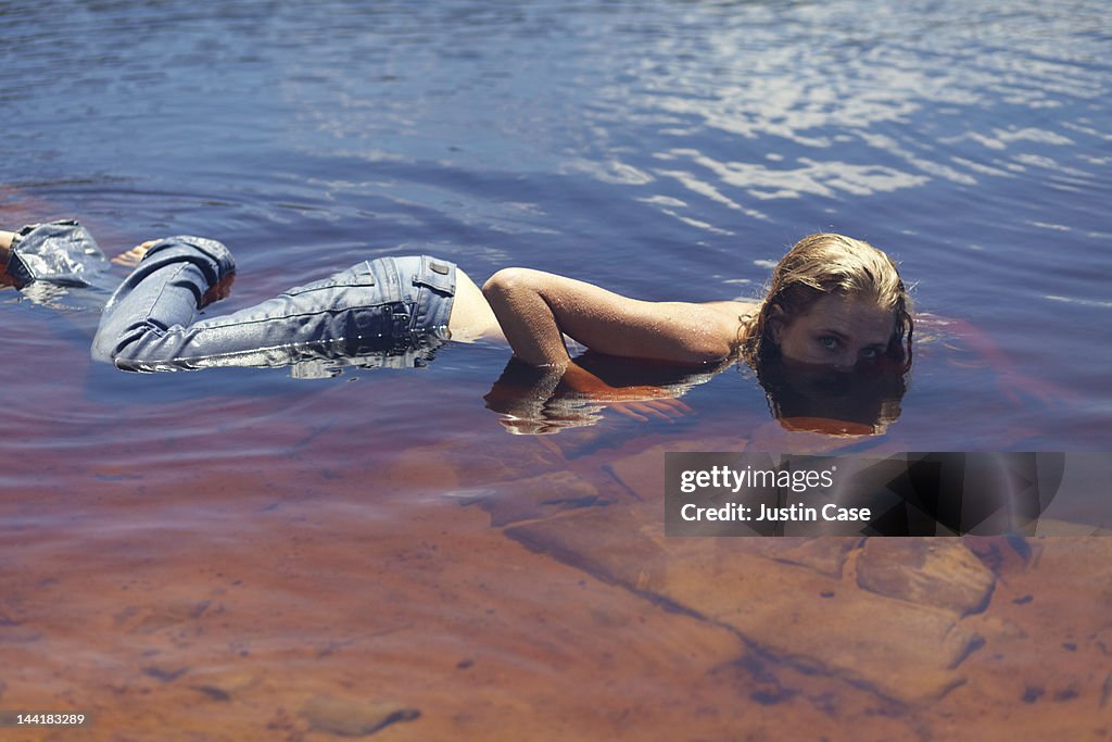 Woman lying in a lake, half covered with water