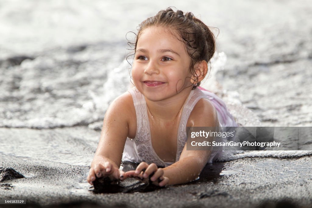 Happy girl on black sand beach in Hilo