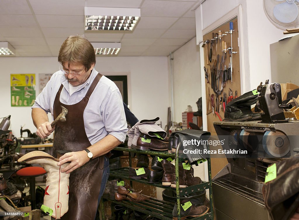 Repair man fixes sole of shoe