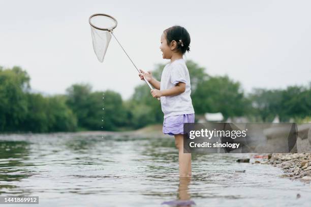 little girl is playing in river - two girls fishing in a stream stock pictures, royalty-free photos & images