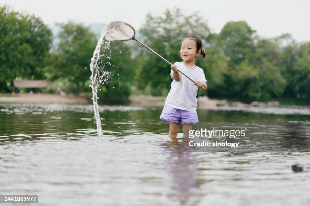 little girl is playing in river - kids at river stock pictures, royalty-free photos & images