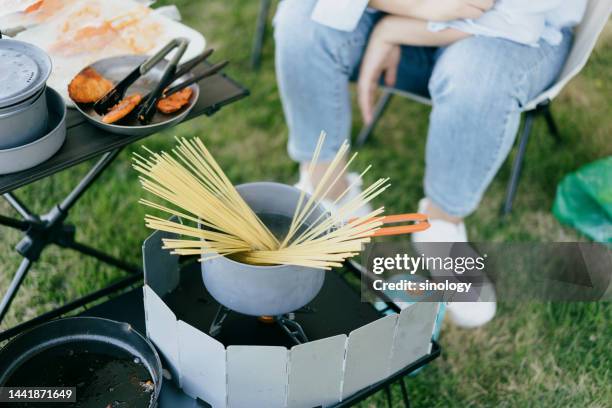 asian woman is cooking noodles at camping in the park - sunset bay state park stockfoto's en -beelden