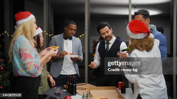 group of multiracial business people enjoying eating pizza and celebrating christmas together at office after work - glass bottle white bg stock pictures, royalty-free photos & images