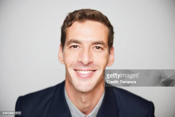 portrait of handsome short and wavy haired slim mid adult businessman with a friendly smile - wavy hair man stock pictures, royalty-free photos & images