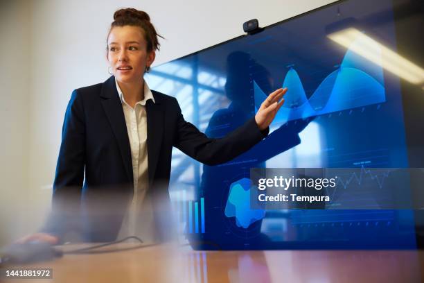 joven adulta explicando gráficos en una presentación de negocios - presentación de diapositvas fotografías e imágenes de stock