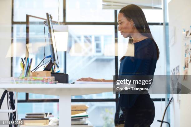 modern business office with standing desk where an african-american woman uses a computer - ergonomics bildbanksfoton och bilder