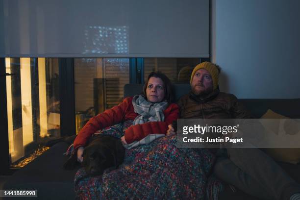 couple watching tv - cold temperature inside stock pictures, royalty-free photos & images