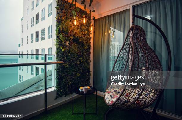 ratan hanging chair with white pillow on balcony - hanging chair stock pictures, royalty-free photos & images