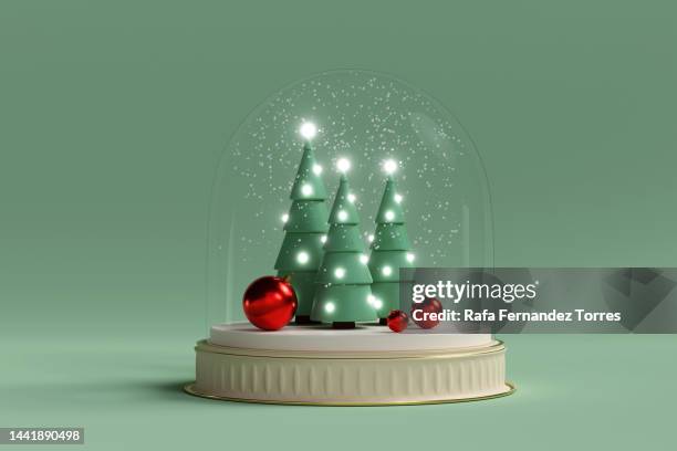 christmas trees and balls under snow in a glass dome. creative still life with copy space - christmas snow globe stock pictures, royalty-free photos & images