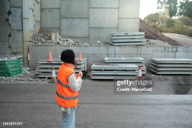 female engineer inspecting materials in a highway bridge construction - traffic management stock pictures, royalty-free photos & images