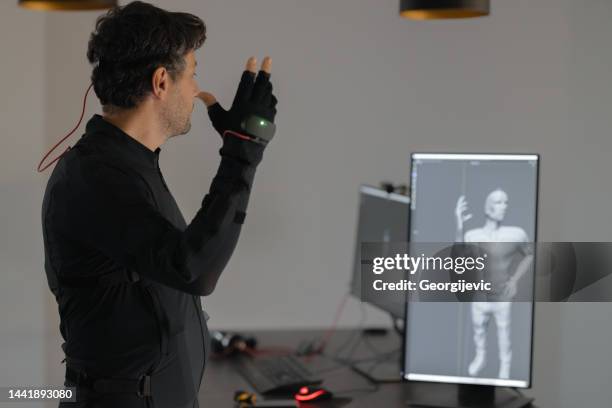 um cara caucasiano está criando uma animação 3d usando um traje inteligente de maquete. - animator - fotografias e filmes do acervo