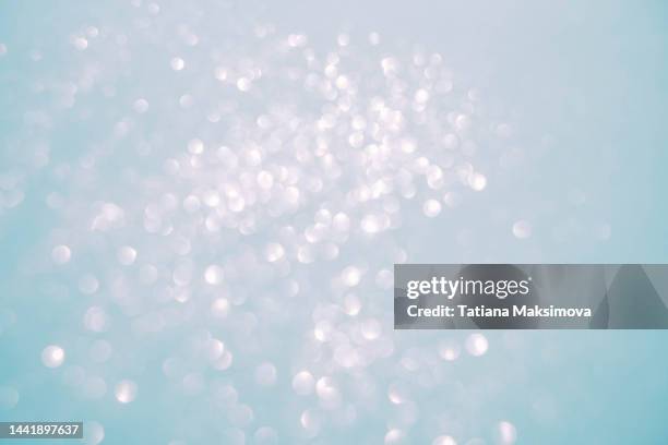 festive blue pastel background with silver bokeh. copy space. - glittering snow stock pictures, royalty-free photos & images