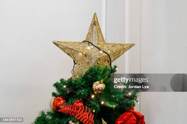 star shape on christmas tree - tree topper stock pictures, royalty-free photos & images