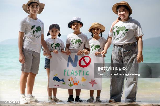 portraits, groups of children's volunteers they are collecting plastic waste on the beach to help reduce marine pollution. - fat asian boy stock pictures, royalty-free photos & images