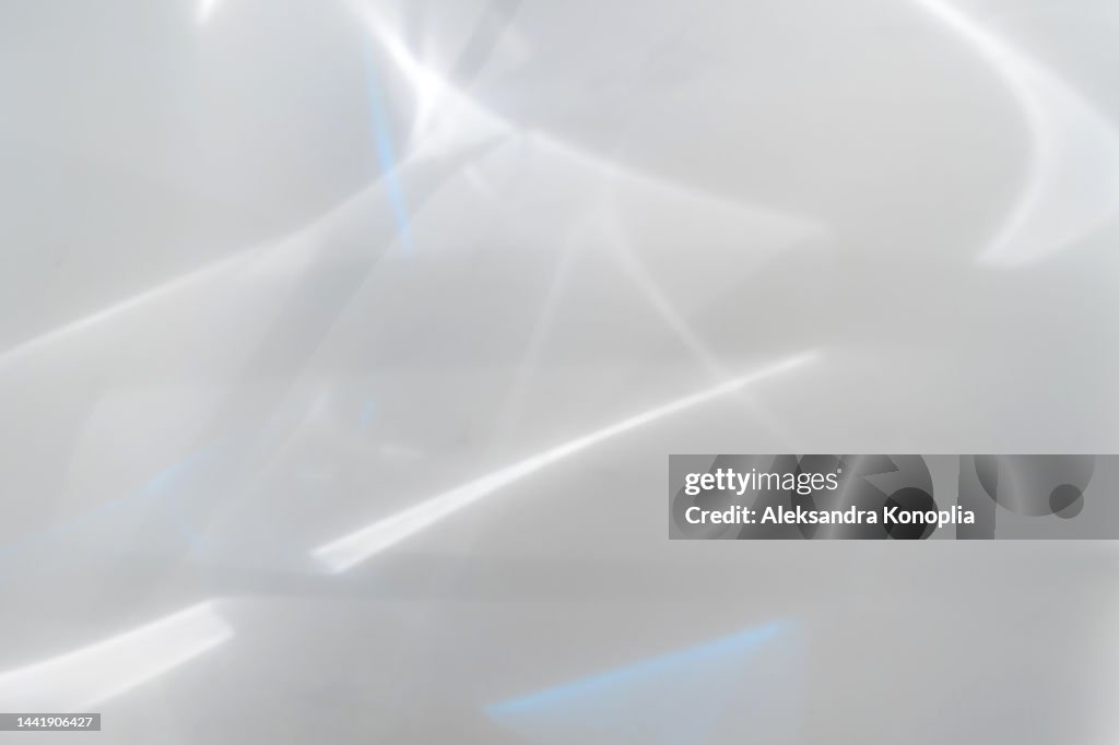 Blurred dreamy surreal rainbow light refraction texture overlay effect on white wall