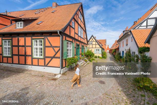 woman visiting the old town of stralsund, germany. - timber framed stock pictures, royalty-free photos & images