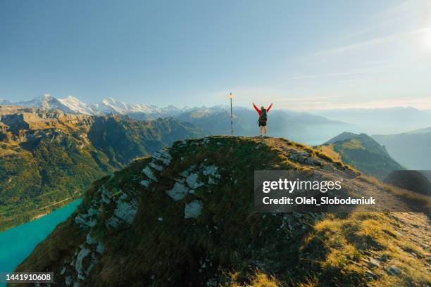 mann wandert auf dem hintergrund von interlaken in den schweizer alpen in der nähe von straßenschild - schild schweiz stock-fotos und bilder