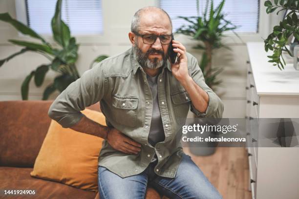 mature adult man illness (mobile phone) - virilha humana imagens e fotografias de stock