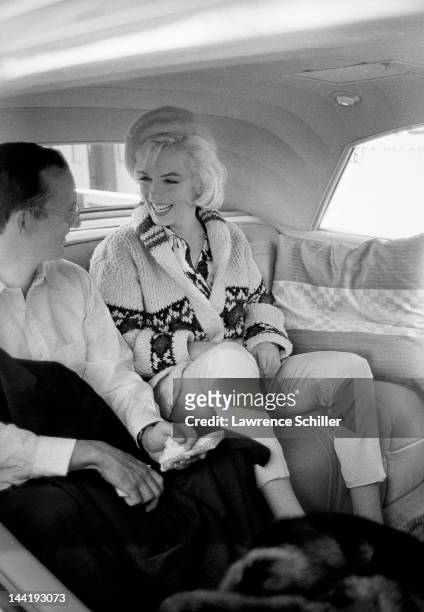 American actors Marilyn Monroe and Wally Cox share a laugh as they ride together after leaving the studio following a day's filming on the set of...