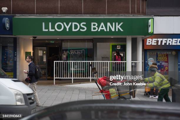 Sanitation Worker cleans the street outside a Lloyds Bank branch on the Heathway on November 14, 2022 in Dagenham, London.