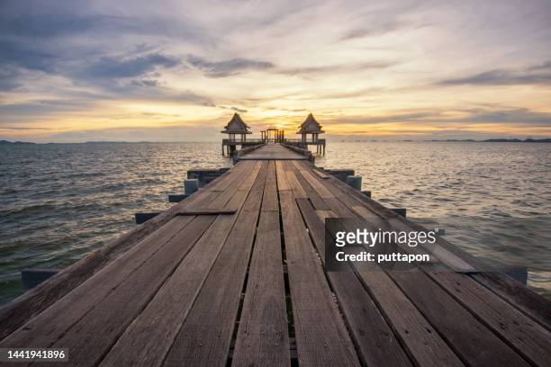 beautiful evening landscape of twilight wooden bridge at sunset old abandoned pavilion in the sea - chonburi province stock pictures, royalty-free photos & images