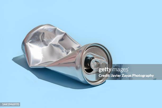 crumpled aluminum can on blue background - blank packaging stock-fotos und bilder