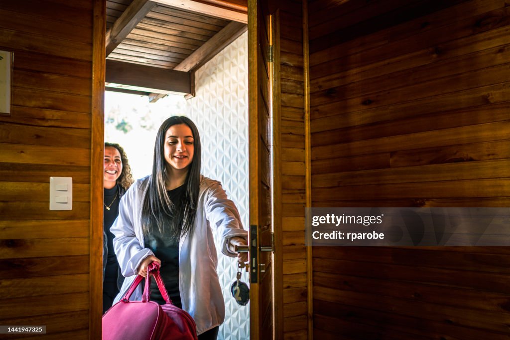 Girlfriends traveling at the door arriving from trip
