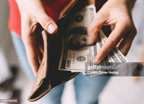 unrecognizable woman shows a few banknotes in her purse - portafoglio foto e immagini stock