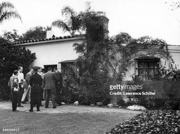 Journalists and a police officer stand outside the home of American actress Marilyn Monroe, Los Angeles, California, August 5, 1962. She had been...