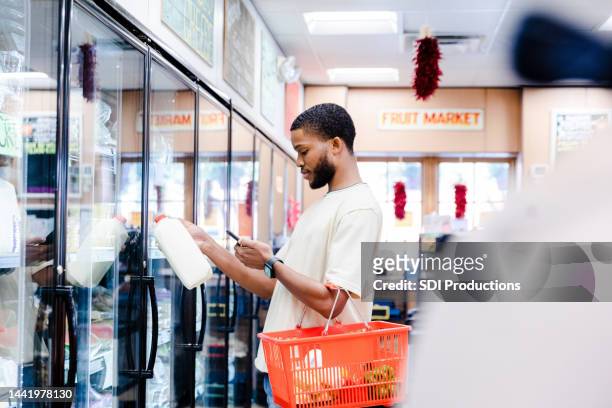 young adult male reads a message - consumer confidence stock pictures, royalty-free photos & images