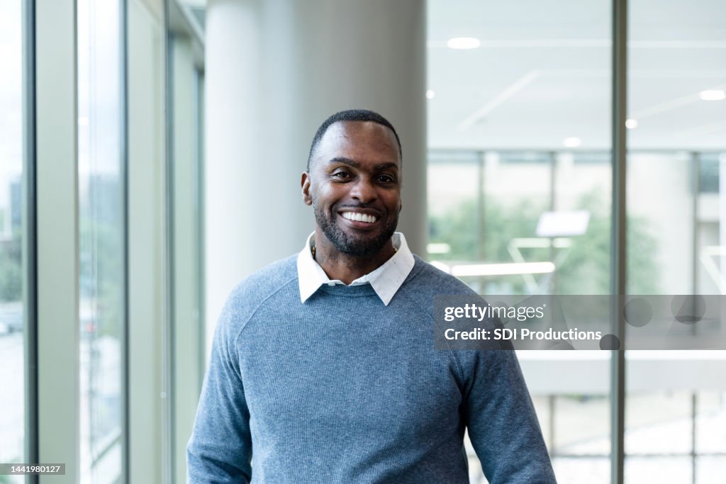 Successful mature adult businessman stands in corporate office