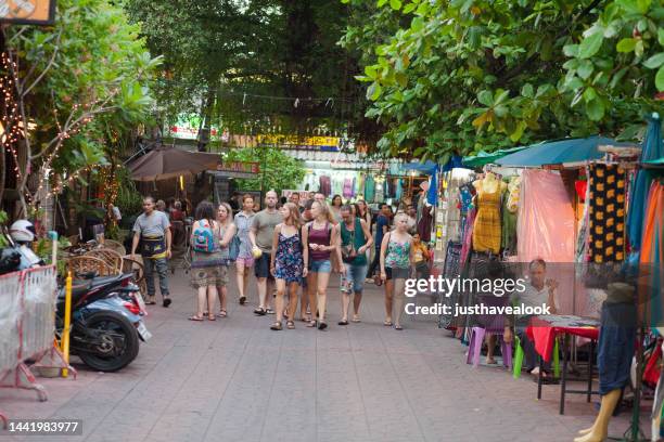 large group of young white adults is walking in old district phra kakhon of bangkok - khao san road stock pictures, royalty-free photos & images