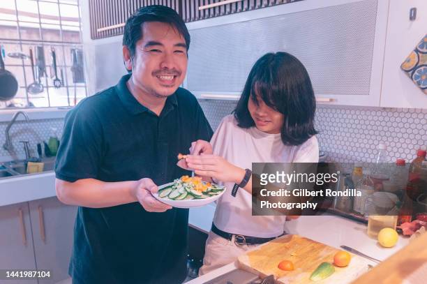 father and daughter working in the kitchen - philippines family stock pictures, royalty-free photos & images