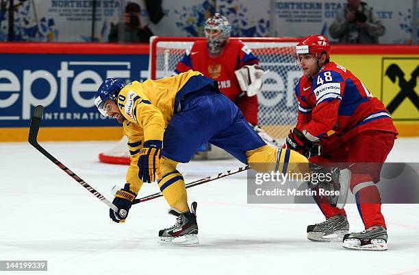 Yevgeni Biryukov of Russia and Henrik Zetterberg of Sweden battle for the puck during the IIHF World Championship group S match between Russia and...