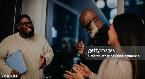 laughing colleagues working late enjoy a jovial moment - party board meets stock pictures, royalty-free photos & images