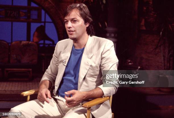 View of the English Rock musician David Gilmour, of the band Pink Floyd, as he sits in a director's chair during an interview on MTV at Teletronic...