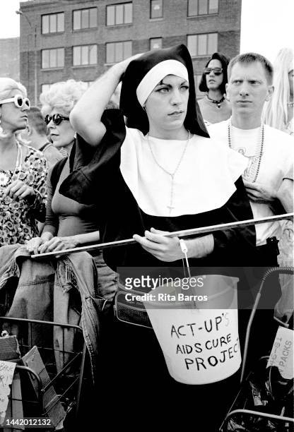 View of attendee, dressed as a nun and holding an ACT UP collection bucket, during Wigstock, an annual drag festival, in Tompkins Square Park, New...