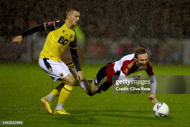 Dan Moss of Woking FC is tackled by Billy Bodin of Oxford United during the Emirates FA Cup First Round match between Woking FC and Oxford United at...