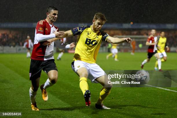 Stuart Findlay of Oxford United holds off Padraig Arnold of Woking FC during the Emirates FA Cup First Round match between Woking FC and Oxford...