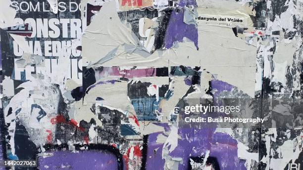 scratched layers of posters and placards on a street wall - poster rip stock pictures, royalty-free photos & images