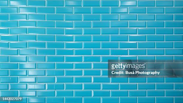 bright blue brick tiled wall - tiled floor stock-fotos und bilder