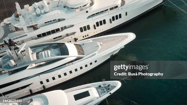 aerial view of luxury yachts moored by dockyard - yacht foto e immagini stock
