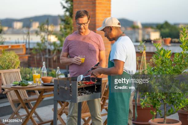 man preparing barbecue grill - man made stock pictures, royalty-free photos & images