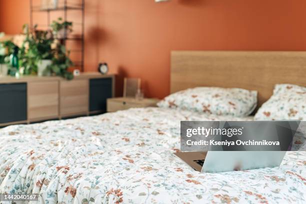 close up white coffee cup and laptop on the bed in morning time with soft light from window, focus on cup - confort at hotel bedroom ストックフォトと画像